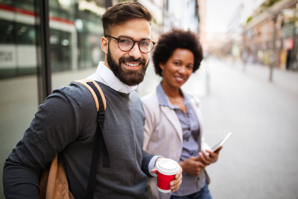 a man holding a cup and a woman standing next to him